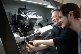 Christian B. und sein Ausbilder an der modernen Industriemaschine Christian B. und sein Ausbilder an der modernen Industriemaschine